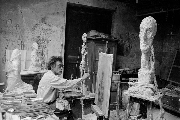 Giacometti en peignant dans son atelier à Paris, à côté La Grande Tête, Paris, ca. 1957 Photo de Ernst Scheidegger © 2018 Stiftung Ernst Scheidegger-Archiv, Zürich